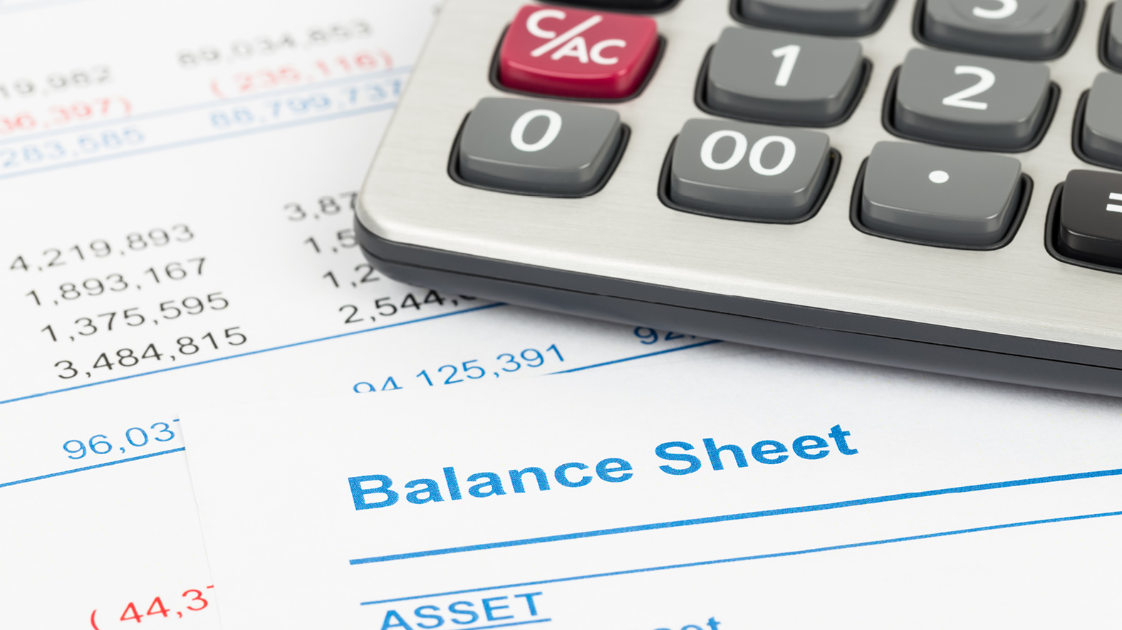 A calculator laying on a balance sheet