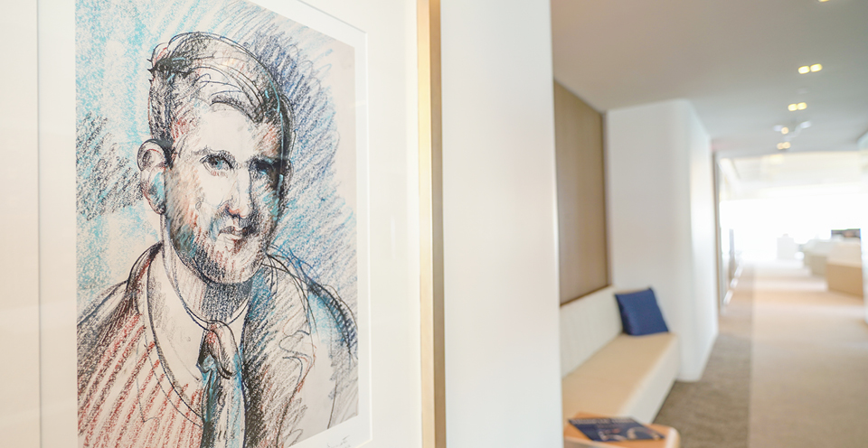 A framed sketching of Wm. Polk Carey in blues and reds, hanging on the hallway of the office in One Manhattan West, New York City, United States.
