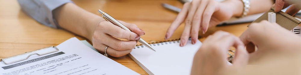 Hands over an empty notepad with paperwork titled 'insurance'