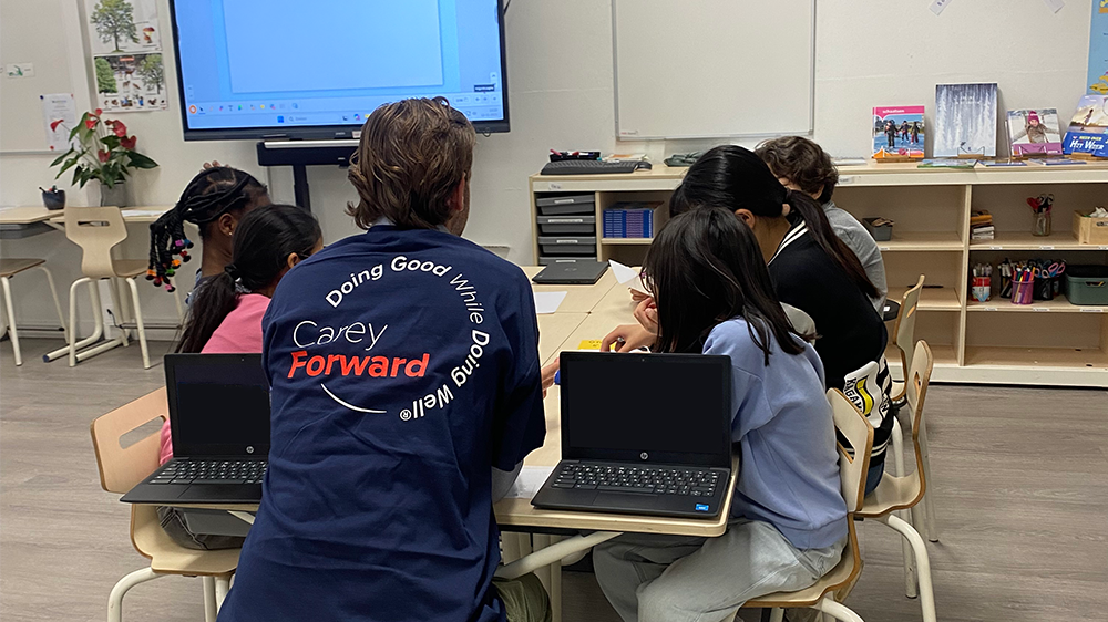 An Amsterdam W. P. Carey employee teaching students introductory programming