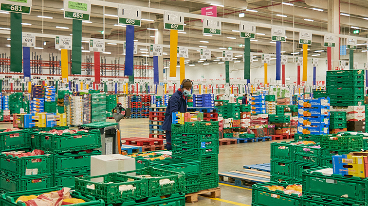 WPC Sonae Interior View of Warehouse with Worker Surrounded by Produce