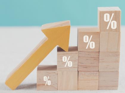 Wooden blocks stacked like stairs, percentage signs are on the top block in each column, a wooden arrow lies on the blocks pointing up to the top block