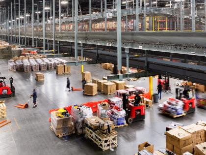 Inside a busy warehouse with lots of cardboard boxes and employees, owned by W. P. Carey