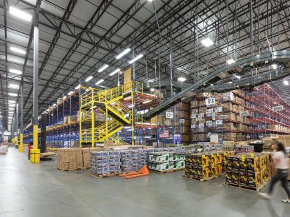 Inside of a warehouse with stacked boxes and machinery, owned by W. P. Carey