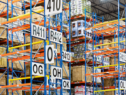 Shelves leading up to the ceiling stacked with cardboard boxes in a warehouse