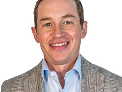 Rob Whirty at W. P. Carey (WPC); a 30-something man with short brown hair in a blue button-up and brown sports coat with a smile