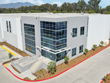 Exterior of an industrial facility with white walls and large glass windows.