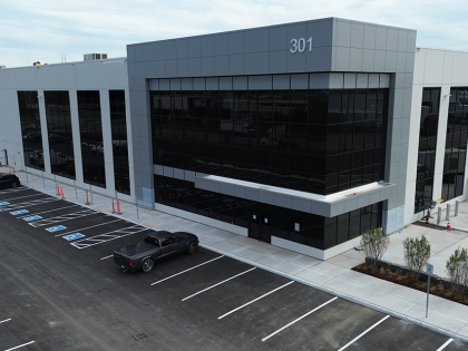 Exterior of an industrial facility with white walls and large glass windows.