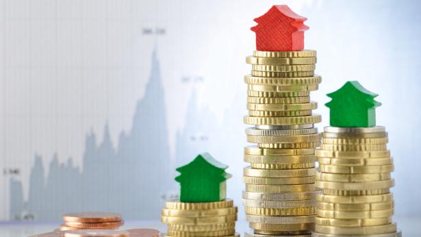 Image of green and red houses on top of stacks of coin