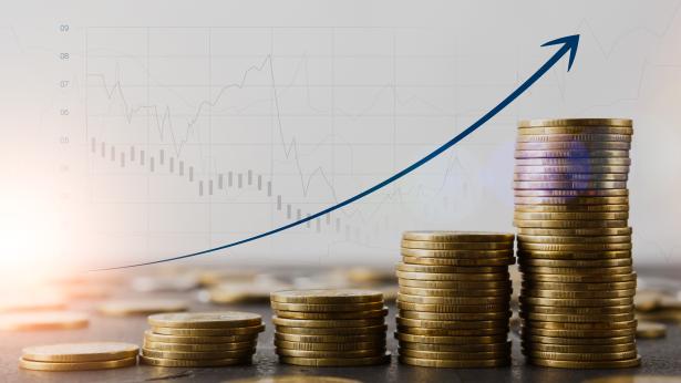 Image of coin stacks growing and arrow going upward representing sale-leasebacks on the rise despite rising interest rates