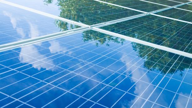 Photo of solar panels with reflection of trees