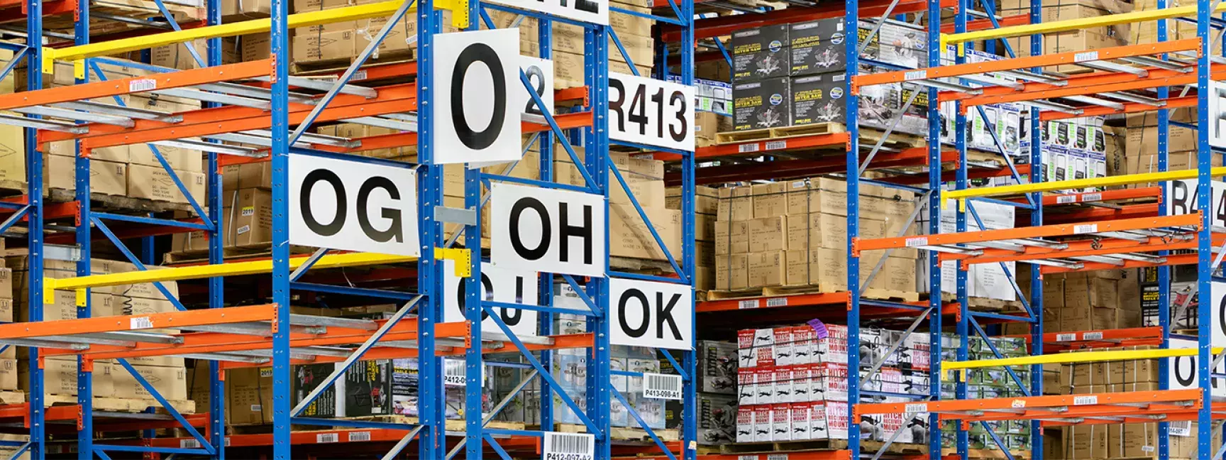 Shelves leading up to the ceiling stacked with cardboard boxes in a warehouse