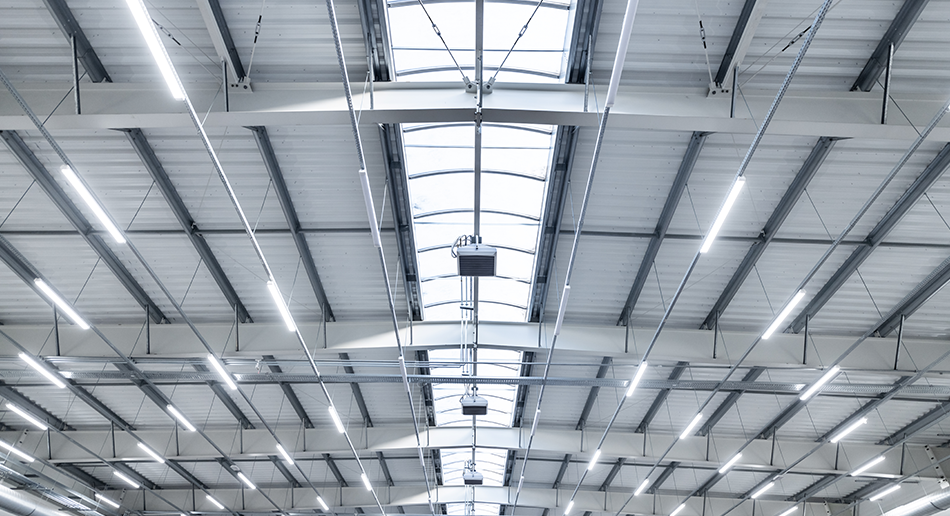Warehouse ceiling with many lights to represent W. P. Carey's energy efficient LED lighting systems